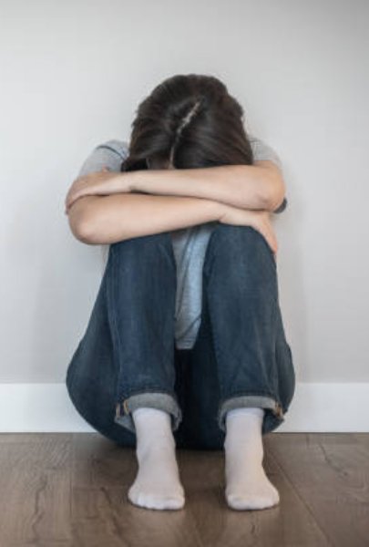 Síntomas de la depresión Persona con expresión triste sentada sola representando síntomas de depresión como tristeza y apatía